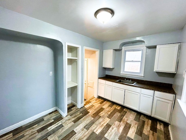 kitchen featuring sink, white cabinets, and dark wood-type flooring