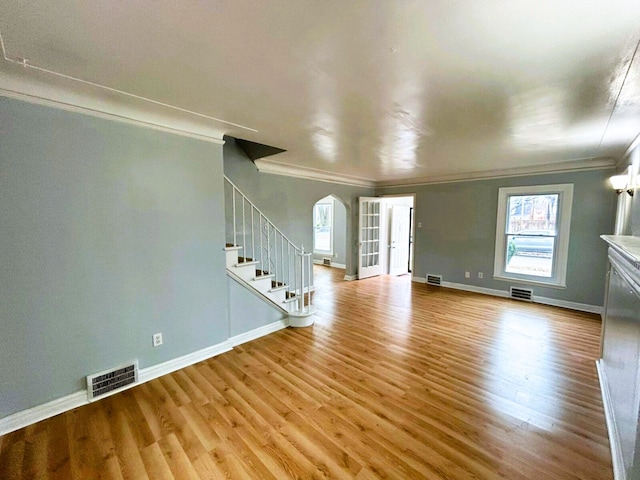 unfurnished living room featuring light hardwood / wood-style floors and crown molding