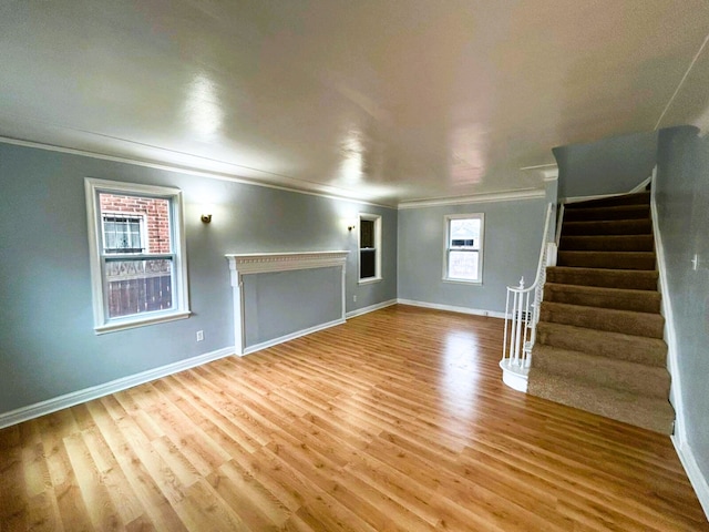 unfurnished living room featuring hardwood / wood-style flooring and crown molding