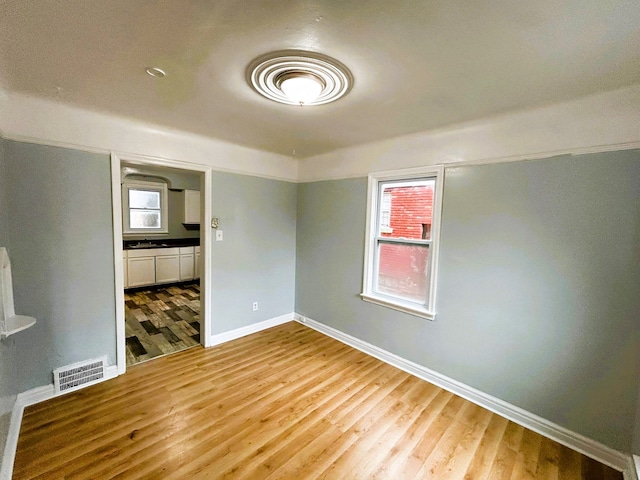 spare room featuring wood-type flooring and sink