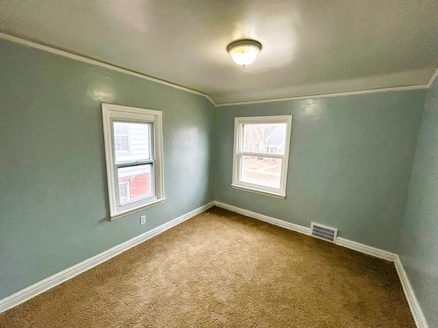 empty room with carpet floors, crown molding, and vaulted ceiling