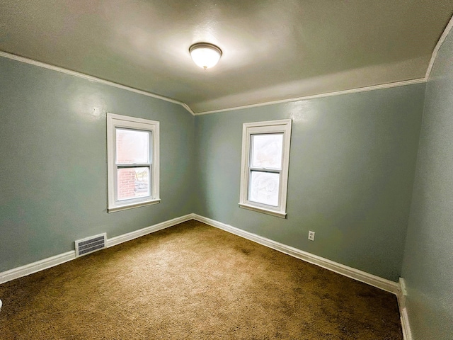 carpeted empty room with crown molding, a wealth of natural light, and lofted ceiling