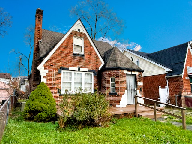 view of front of house featuring brick siding, a chimney, and roof with shingles