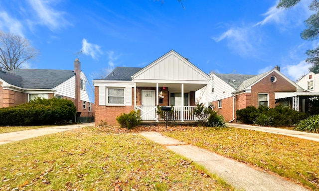 bungalow-style home with a front lawn and covered porch