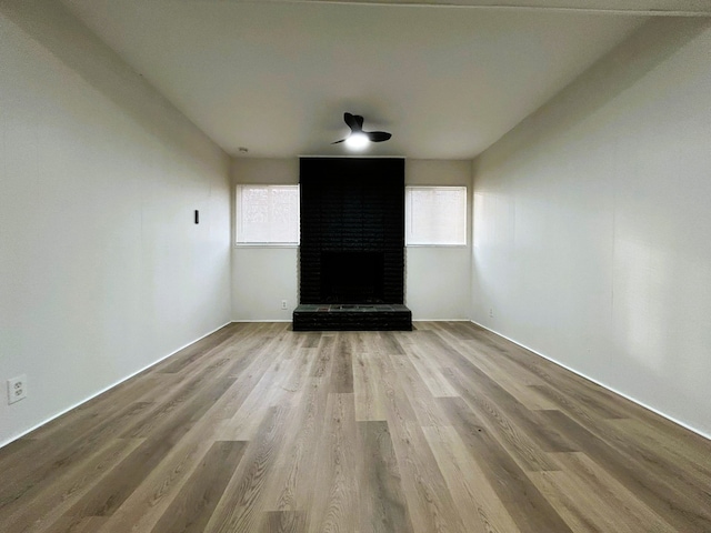 unfurnished living room featuring a fireplace and light hardwood / wood-style flooring