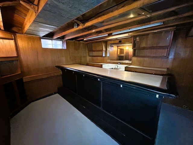 bar featuring sink and wooden walls