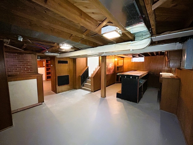 basement featuring wood walls