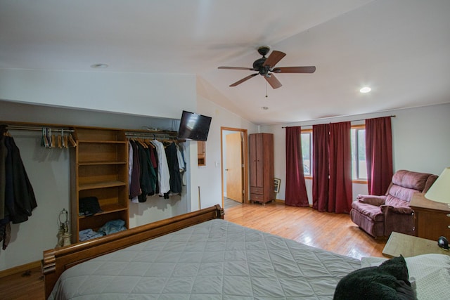 bedroom with a closet, light hardwood / wood-style flooring, vaulted ceiling, and ceiling fan