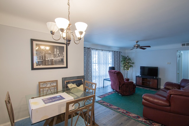 dining area featuring ceiling fan with notable chandelier and hardwood / wood-style flooring