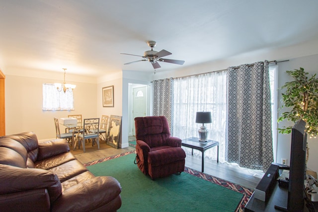 living room featuring hardwood / wood-style floors, ceiling fan with notable chandelier, and a wealth of natural light