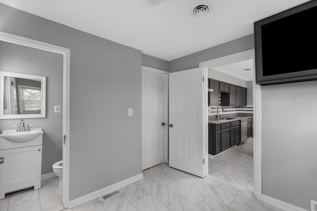 bathroom with decorative backsplash, vanity, and toilet