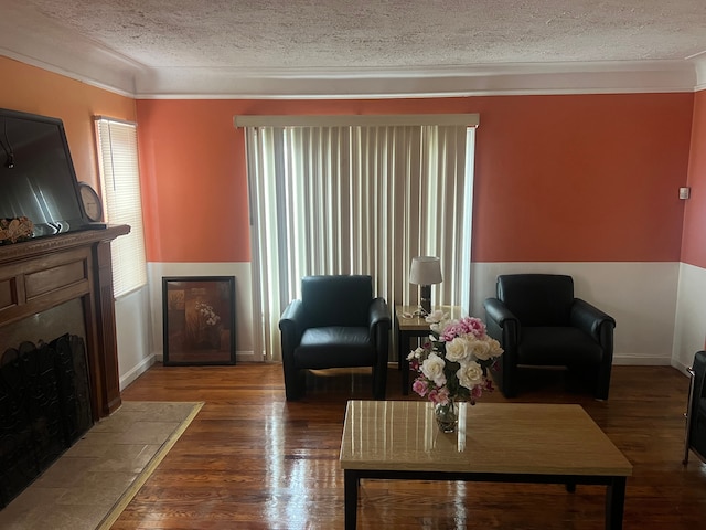 living room with crown molding, dark hardwood / wood-style flooring, and a textured ceiling