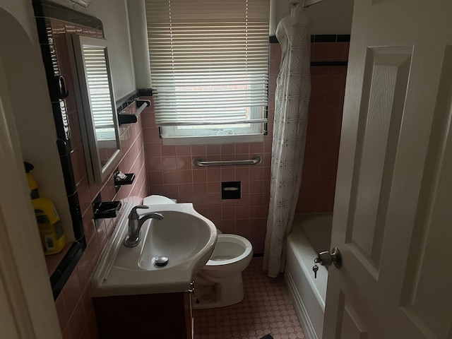 full bathroom featuring shower / bath combination with curtain, vanity, toilet, and tile walls