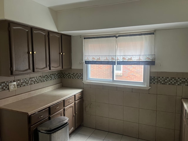 kitchen with dark brown cabinets, light tile patterned floors, and tile walls