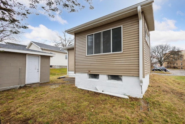 view of side of home with a yard