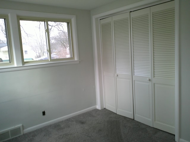 unfurnished bedroom featuring carpet flooring and a closet