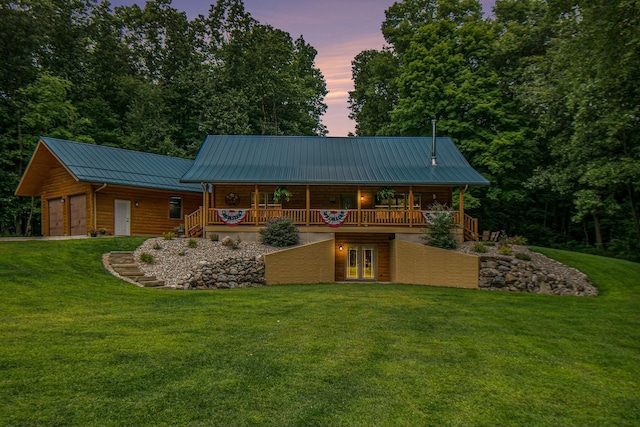 back house at dusk featuring a yard and a garage