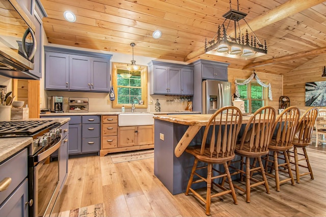 kitchen featuring sink, stainless steel appliances, light hardwood / wood-style flooring, wood walls, and wood ceiling