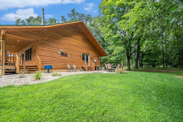 rear view of house featuring a yard and a patio area