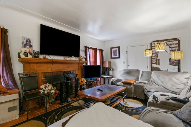 living room with hardwood / wood-style flooring and a brick fireplace