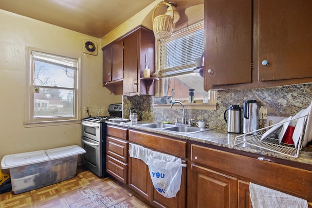 kitchen featuring tasteful backsplash, sink, and range with two ovens