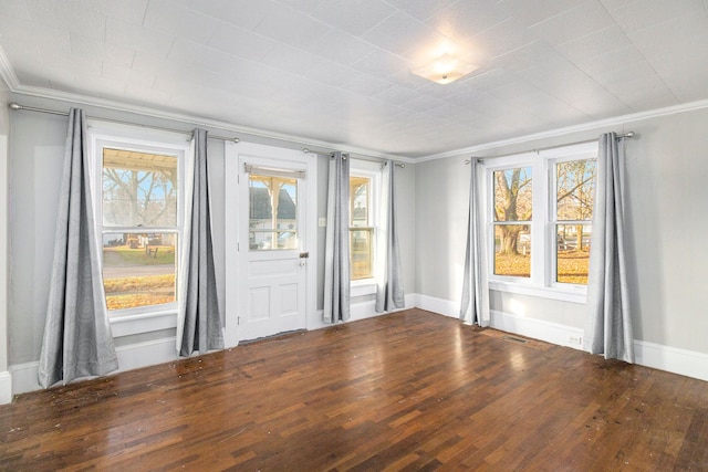 unfurnished room featuring ornamental molding, plenty of natural light, and dark wood-type flooring