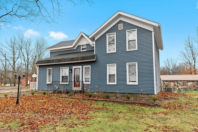 view of front of property with central AC unit and a front yard