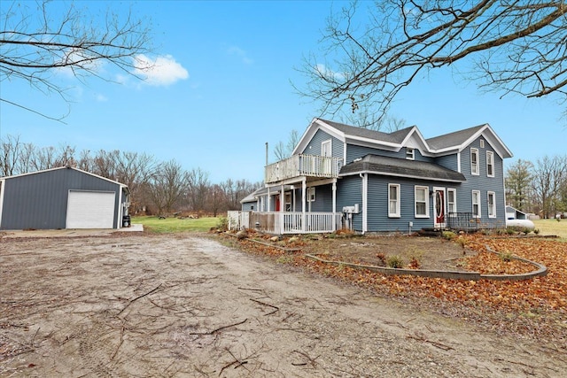 view of property exterior with an outbuilding, a balcony, and a garage