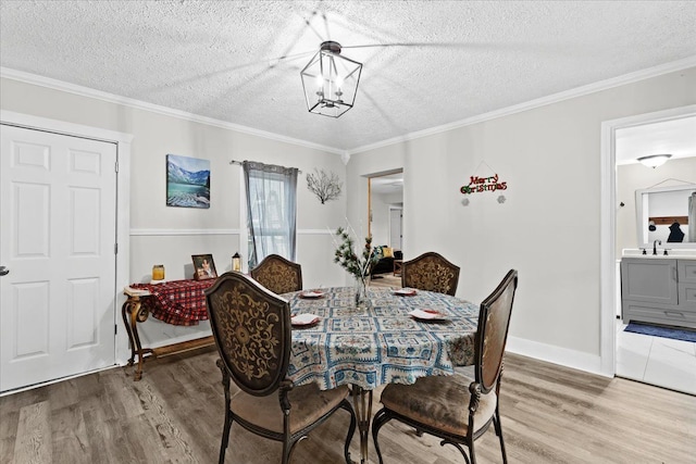 dining area with hardwood / wood-style floors, a textured ceiling, and crown molding