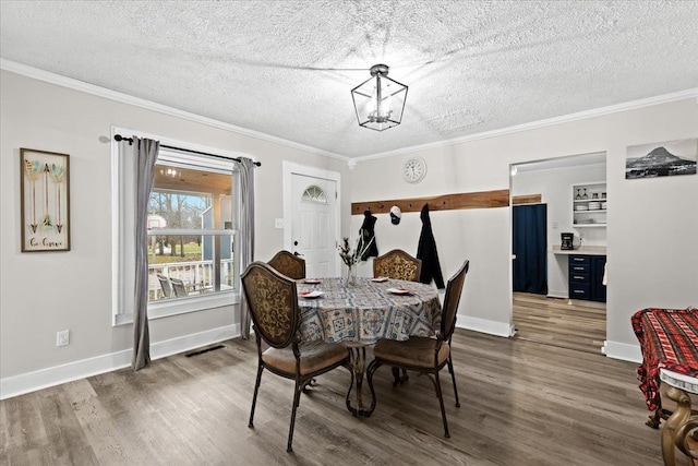 dining area featuring a textured ceiling, crown molding, and dark wood-type flooring