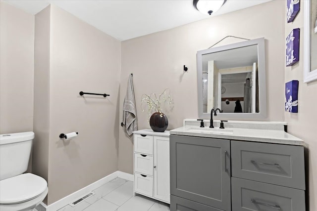 bathroom featuring tile patterned flooring, vanity, and toilet