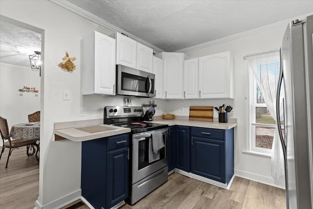 kitchen with a textured ceiling, light wood-type flooring, stainless steel appliances, and crown molding