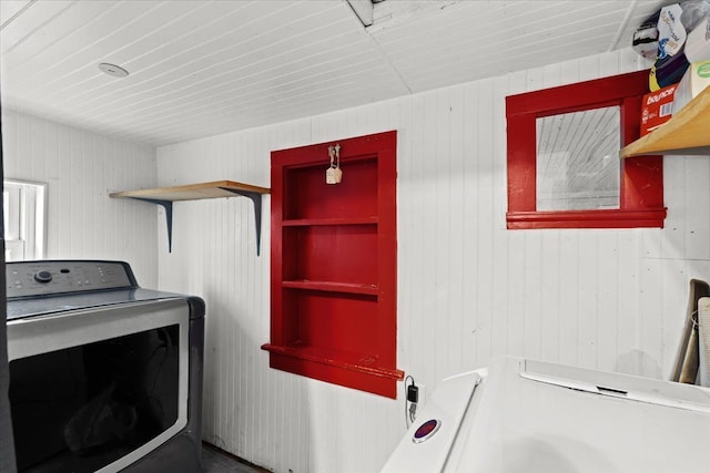 washroom featuring washer / dryer and wood walls