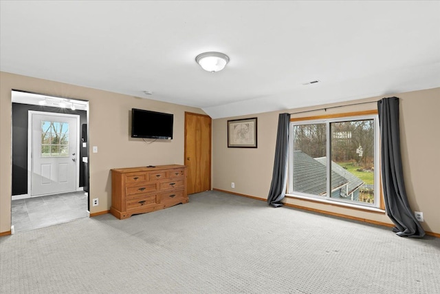 unfurnished living room with light colored carpet and a wealth of natural light