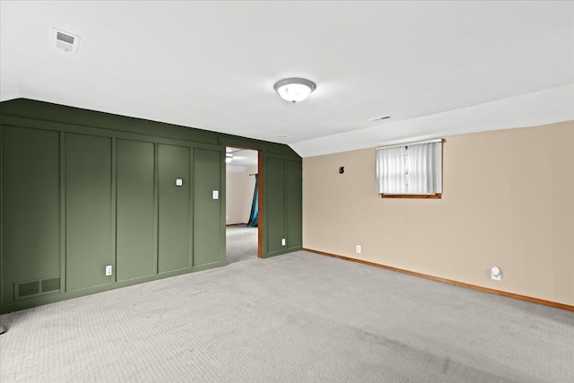 unfurnished bedroom featuring light colored carpet and vaulted ceiling