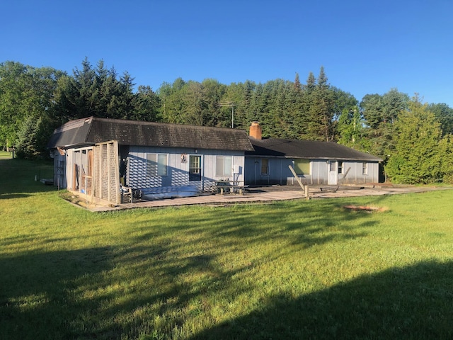 back of property with an outbuilding, a yard, and a patio