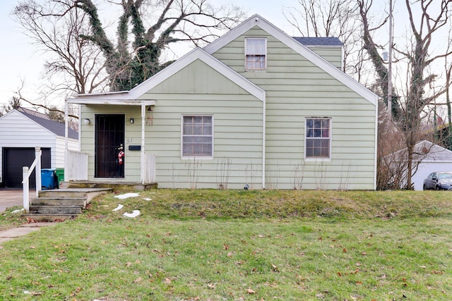 bungalow-style house with an outbuilding, a front yard, and a garage