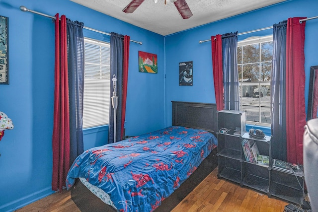 bedroom featuring hardwood / wood-style floors, a textured ceiling, and ceiling fan