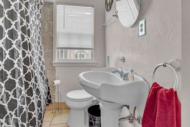 bathroom with tile patterned flooring, a shower with shower curtain, and toilet