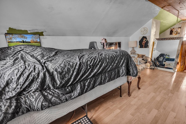 bedroom with hardwood / wood-style floors and vaulted ceiling