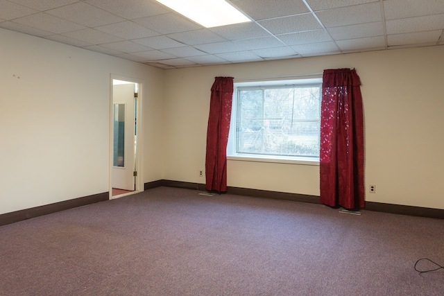 carpeted empty room with a paneled ceiling