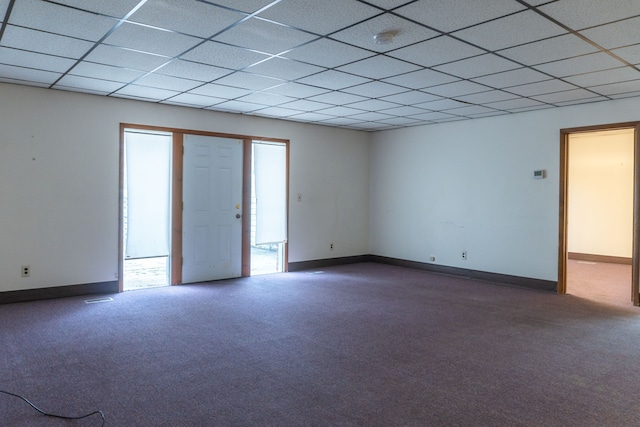 carpeted empty room featuring a drop ceiling