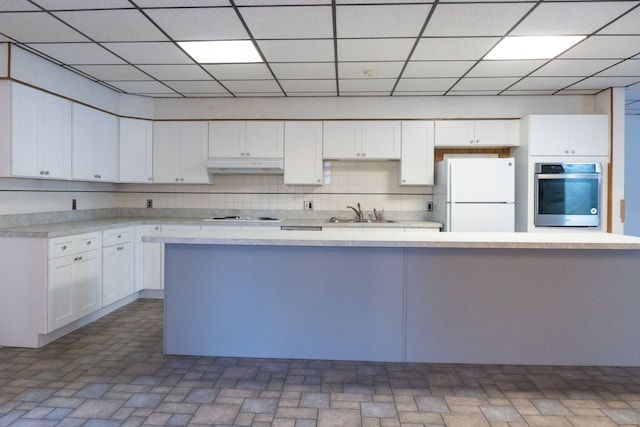 5620 Kaufman St, Dearborn Heights, MI 48125 - kitchen featuring white appliances, under cabinet range hood, white cabinetry, light countertops, and a drop ceiling