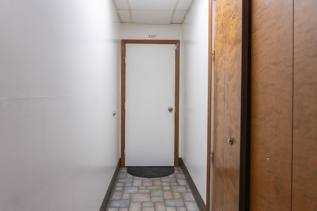 corridor with a paneled ceiling