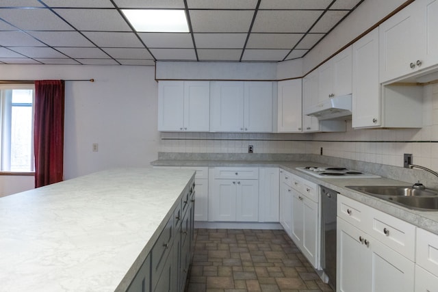 kitchen featuring a paneled ceiling, tasteful backsplash, sink, dishwasher, and white cabinets