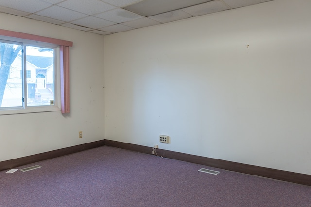 carpeted spare room with a paneled ceiling