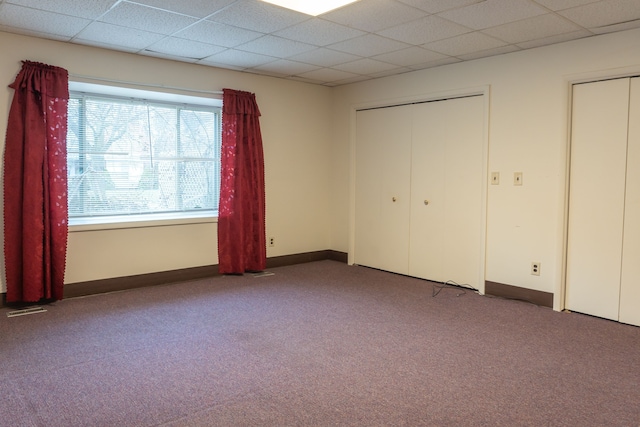 unfurnished bedroom featuring a paneled ceiling and carpet floors