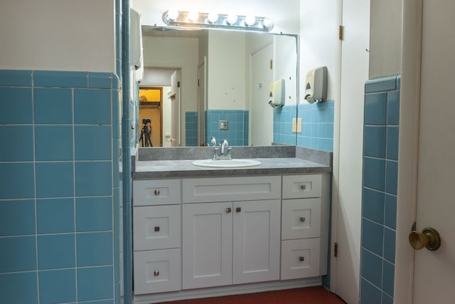 bathroom featuring vanity and tile walls