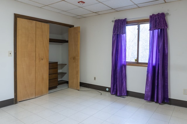 unfurnished bedroom featuring a paneled ceiling and a closet