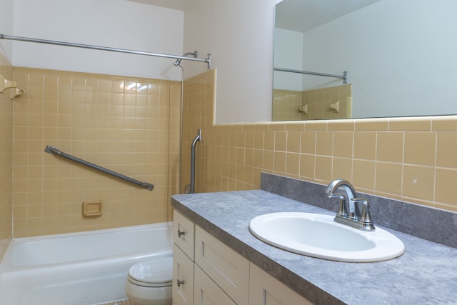 full bathroom with vanity, tiled shower / bath combo, tile walls, and toilet